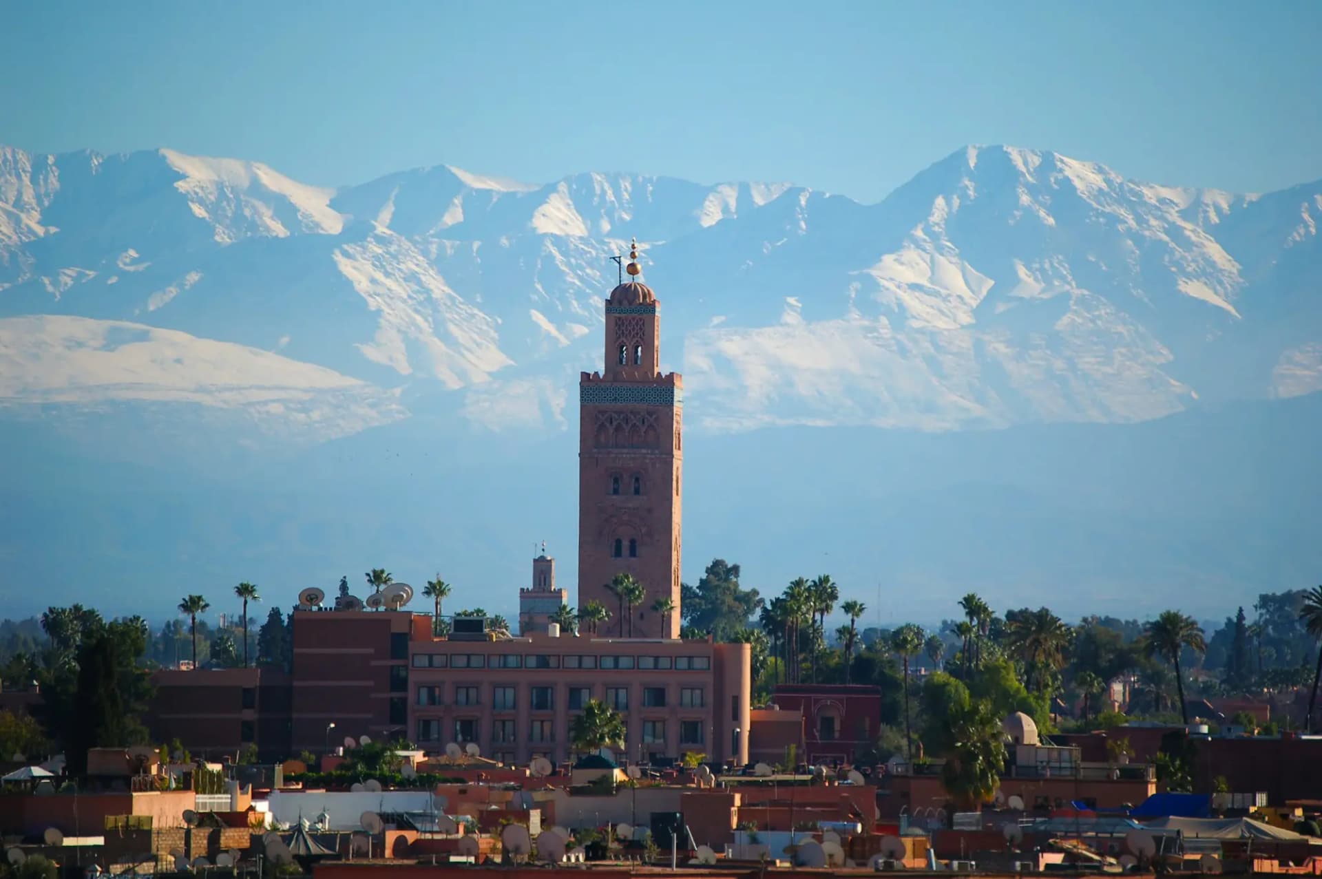 The Koutoubia minaret in Marrakech with the snow-capped High Atlas mountains behind