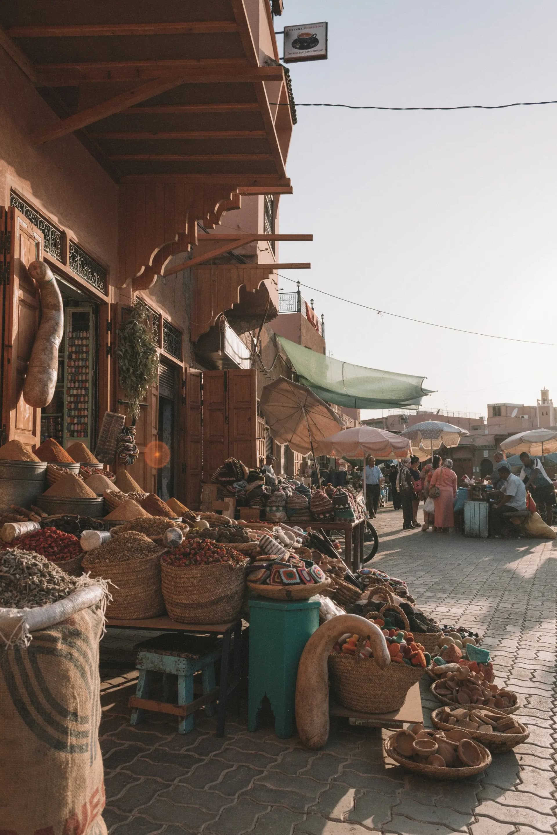 Baskets of spices and dried goods at a busy Moroccan market