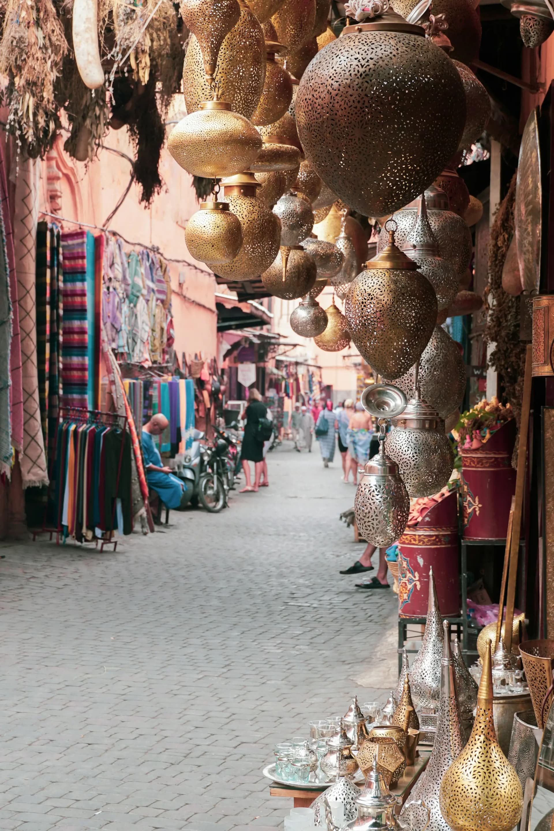 Metal lanterns and textiles hanging along a lane in a Moroccan souk