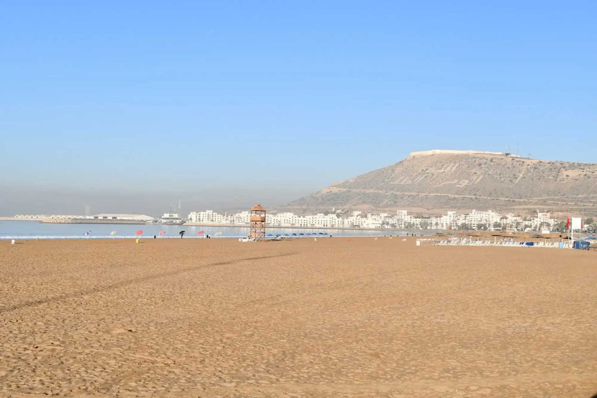 The long beach of Agadir at dusk with the kasbah hill behind