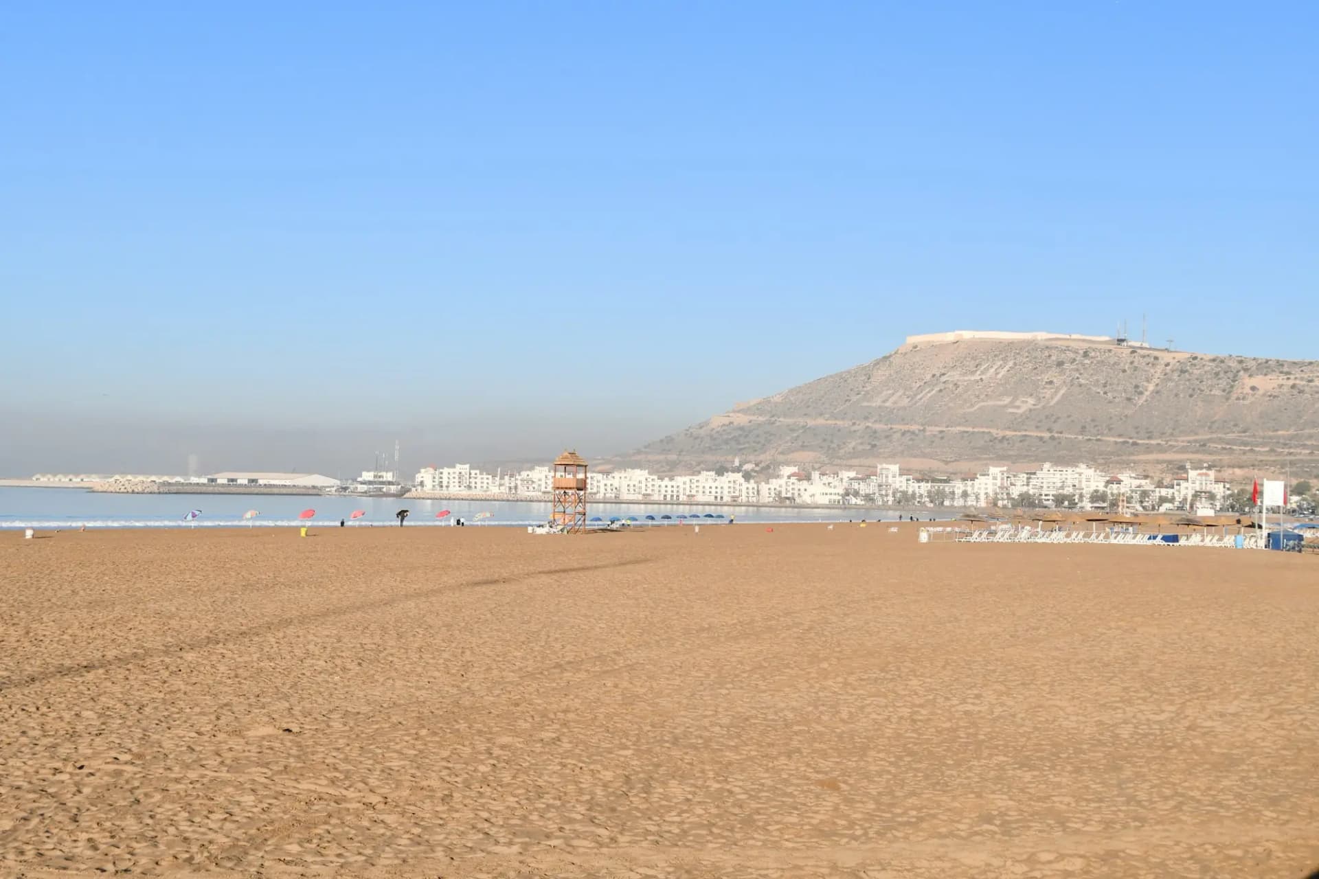 Agadir's wide sandy beach with the Oufella kasbah hill in the distance
