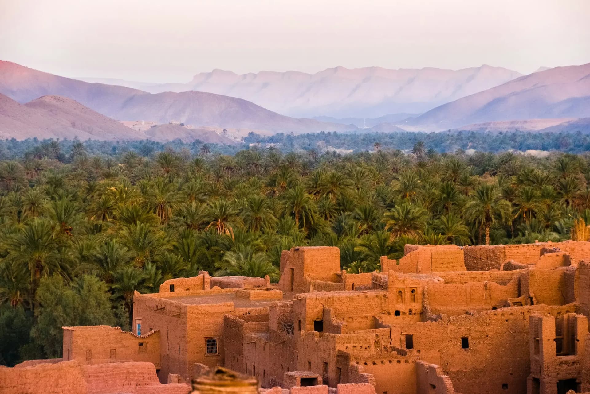 Palm oasis and earthen kasbah below the mountains of southern Morocco